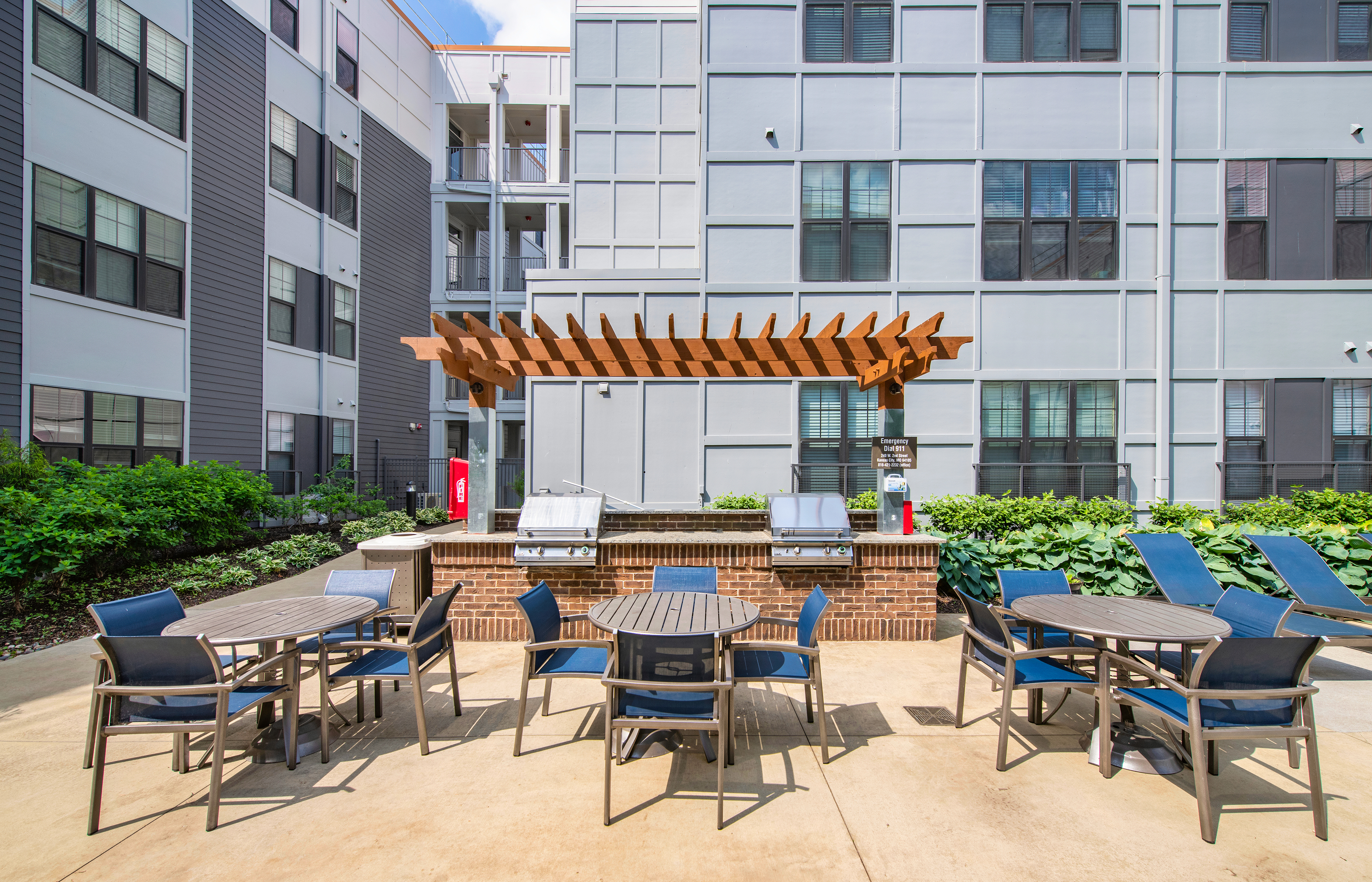 Outdoor double grilling station with patio tables and chairs at Market Station luxury apartments in Kansas City, MO